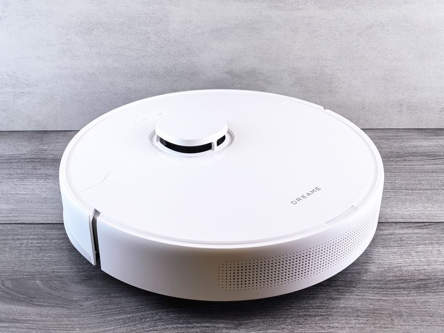Ein moderner Saugroboter mit Absaugstation in einem sauberen, modernen Wohnraum, bereit zur automatischen Reinigung.